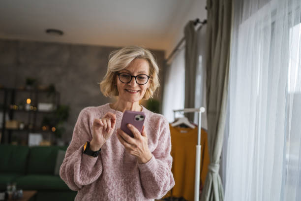 istock One woman mature caucasian female use mobile smart phone sms texting 2105200983