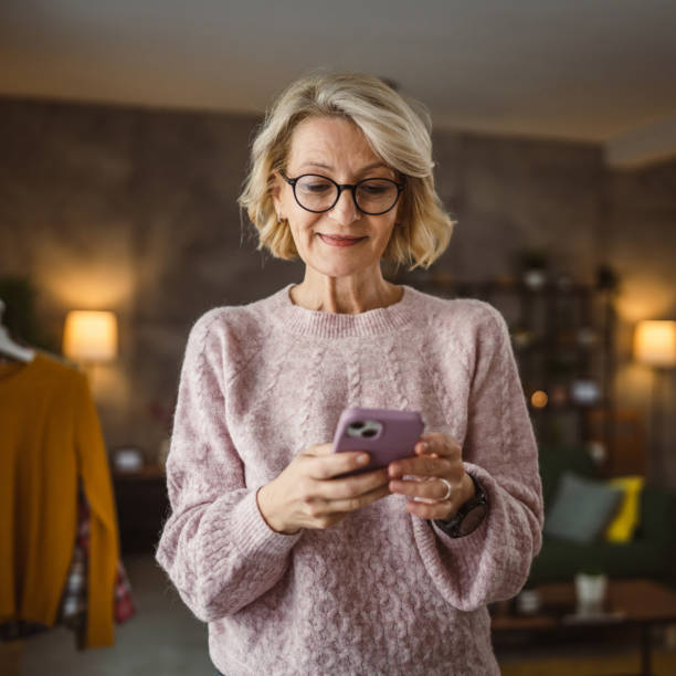 istock One woman mature caucasian female use mobile smart phone sms texting 2105201506