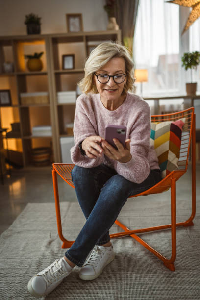 istock One woman mature caucasian female use mobile smart phone sms texting 2105201515