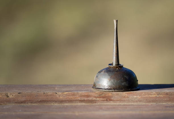 Vintage Small Oilcan Covered in Oil and Dirt on a Wooden Surface with Ample Copy Space
