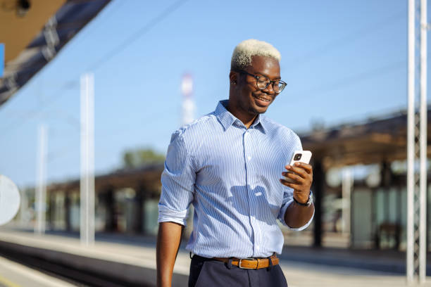 istock Young African American man using smart phone on the train station 2105292249