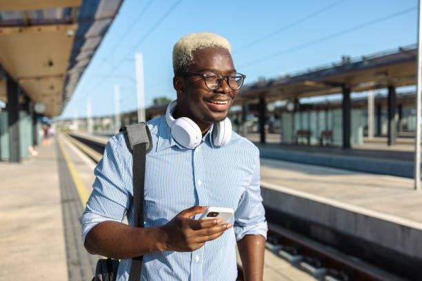 istock Young African American man using smart phone on the train station 2105294334