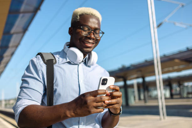 istock Young African American man using smart phone on the train station 2105294336