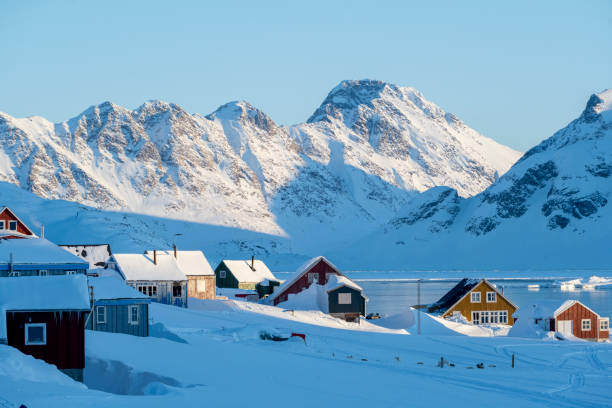 Community on a frozen bay and snowcapped mountains