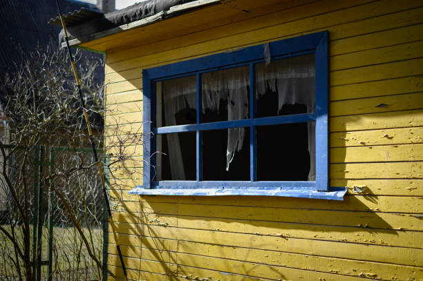 istock Abandoned house in bright yellow and blue colors. Empty window without glass 2105318991