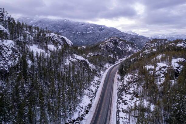 Aerial view of road winding through mountains in winter
