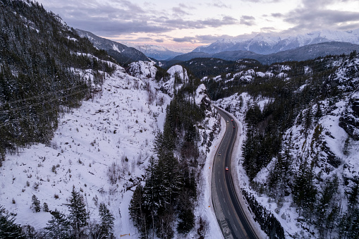 Aerial view of road winding through mountains in winter