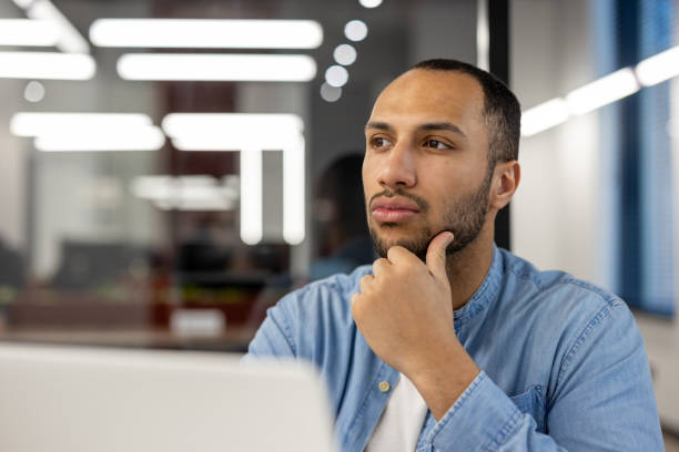 istock Thoughtful professional in a modern office setting looking into the distance 2105340482