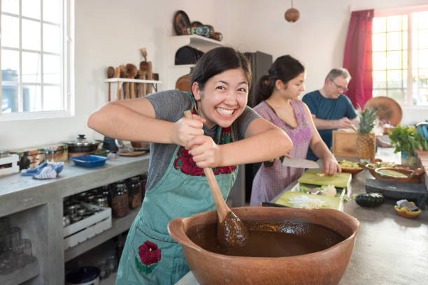 Multiracial Young Woman Having Fun Stirring Mole, Mexican Cooking Class