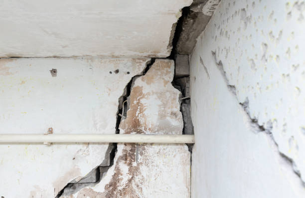 istock Cracked old brick plastered wall. House after the earthquake. Emergency building. Poor quality work during construction. 2105474473