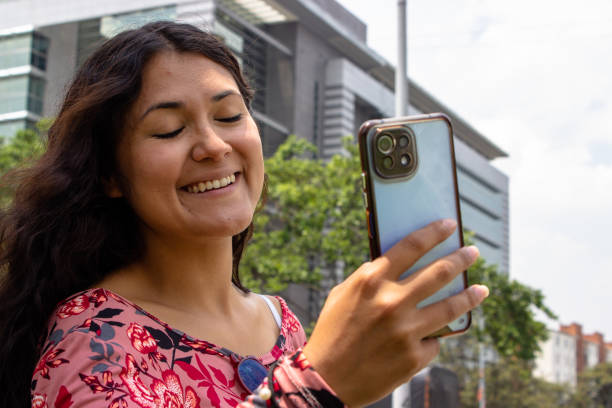istock Young beautiful woman using cell phone in front of modern building 2105478376