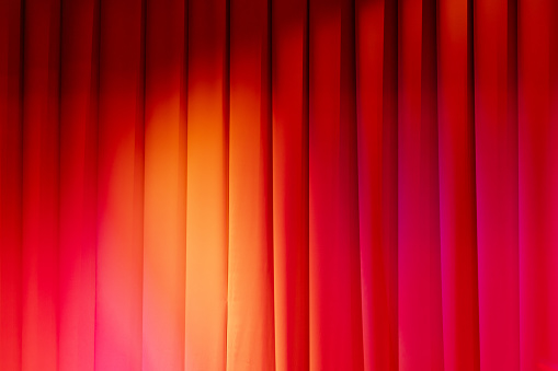 Red theatrical curtain with spot lights illumination, background photo texture