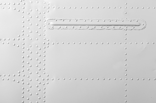 White industrial metal wall with rivets pattern, front view, background photo texture