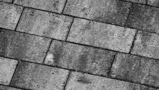 Rough gray concrete cobble road background, paving slabs pattern