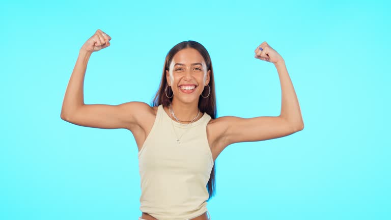 Face, funny and woman flex muscle in studio isolated on a blue background mockup. Portrait, strong arms and happy female person with power, empowerment or challenge, fitness and exercise for workout.