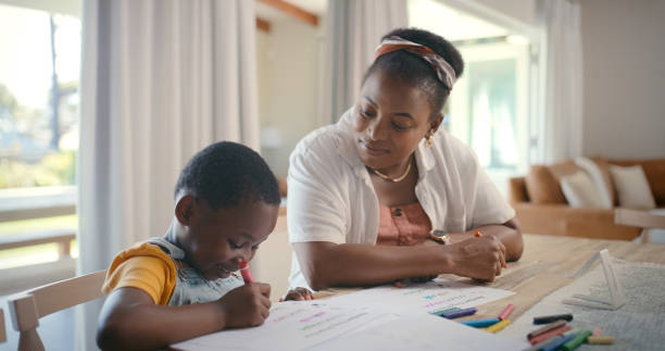 istock Black family, education and mother teaching child in home for development, distance learning or study. Book, homework and drawing with woman helping kid school student in dining room of apartment 2105489312