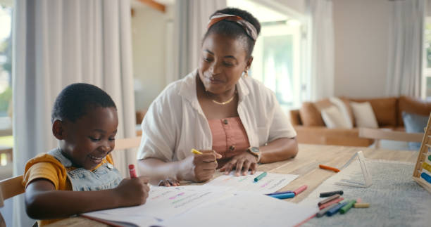 istock Book, education and writing with black family in home for child development, distance learning or study. Color, drawing and homework with woman teaching kid school student in dining room of apartment 2105489319