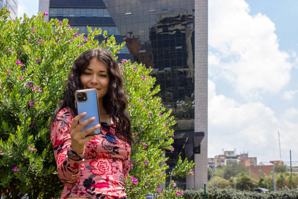 istock Young beautiful woman using cell phone in front of modern building 2105490930