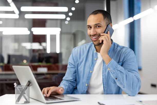 istock Professional man on phone with a laptop at modern office 2105497976