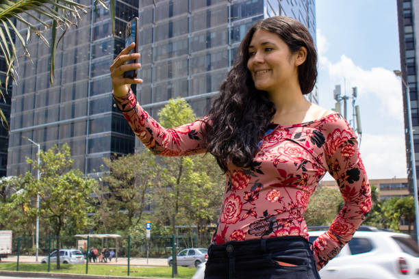 istock Young beautiful woman using cell phone in front of modern building 2105499540