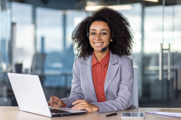 istock Professional woman with headset working at laptop in office 2105504462