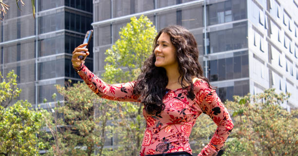 istock Young beautiful woman using cell phone in front of modern building 2105524749