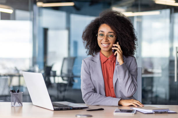 istock Professional woman using phone at modern office desk 2105528984