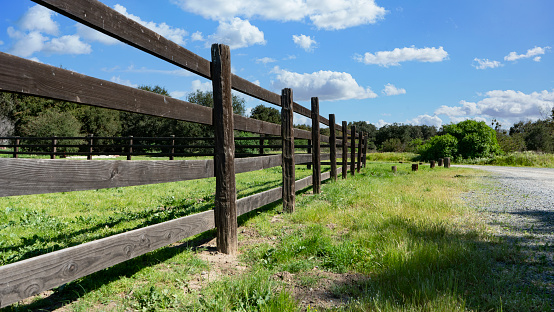 Wooden corral fence in a meadow on a sunny day.