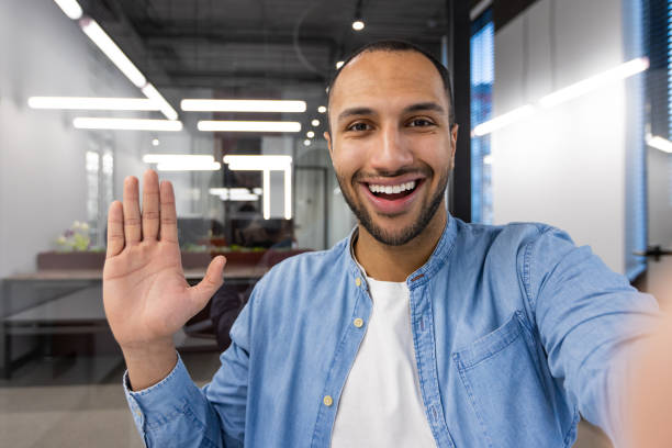 istock A man with a big smile on his face is waving at the camera 2105586040