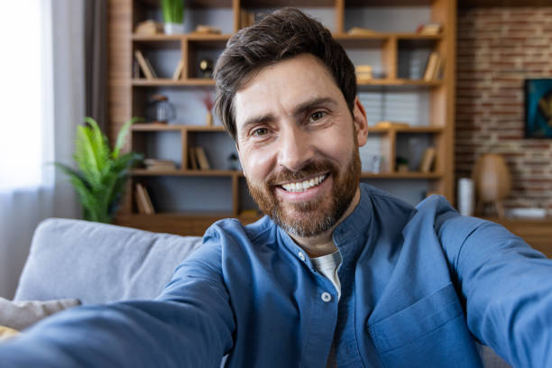 istock Casual man taking a selfie in a cozy room setting 2105615230