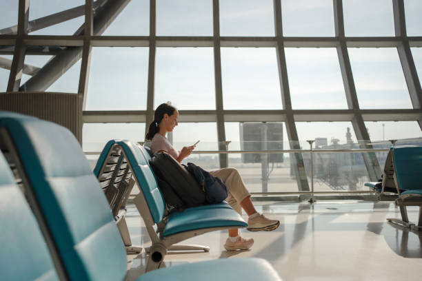 istock Woman is using a phone on the airport 2105626206