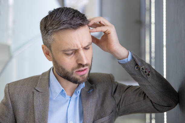istock Concerned businessman in suit scratching head, feeling puzzled and confused, office background 2105638955