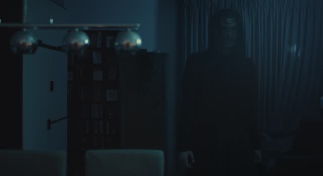 Horror scene - a dark and ominous demon walks through a ghastly living room at night