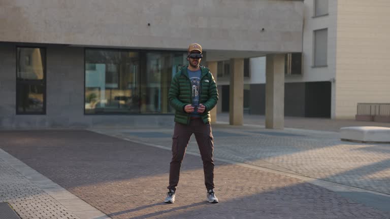 Man in urban setting puts on FPV headset while holding drone controller