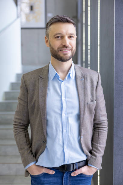 istock Confident professional man in smart casual attire smiling in modern office environment, exuding leadership 2105704915