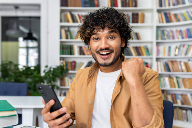 istock Excited young man celebrating with a smartphone 2105710182