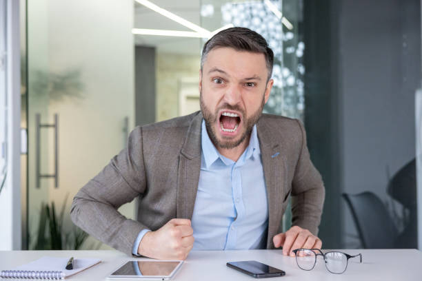 istock Frustrated businessman yelling in modern office setting, emotional stress concept 2105715434