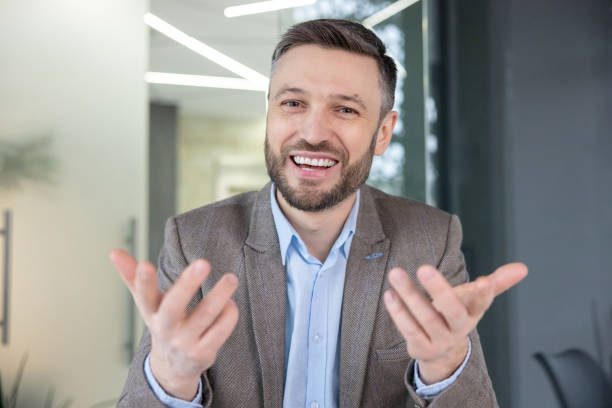 istock Confident businessman with a welcoming gesture in a modern office environment 2105721623