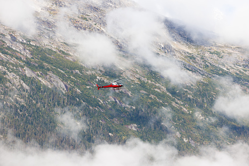 A tourist laden helicopter explores the wild untouched mountain range in Alaska.