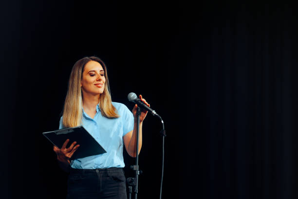 istock Event Presenter Talking into the Microphone Holding Clipboard 2105742166