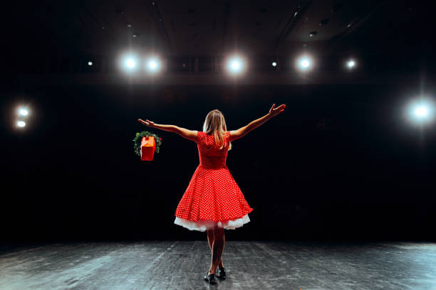 Happy Performer Greeting the Audience Receiving Flowers Talented actress getting standing ovations for her performance stage actress stock pictures, royalty-free photos & images