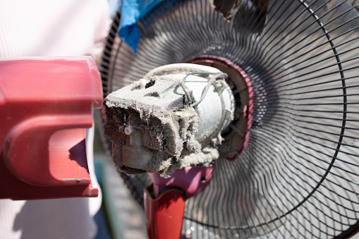 Close up,The electric fan motor was covered in dirt,full of dust inside the fan,dusty clogged motor of electric fan,cleaning,maintenance of home appliances,health care,prevent allergy dust,allergies