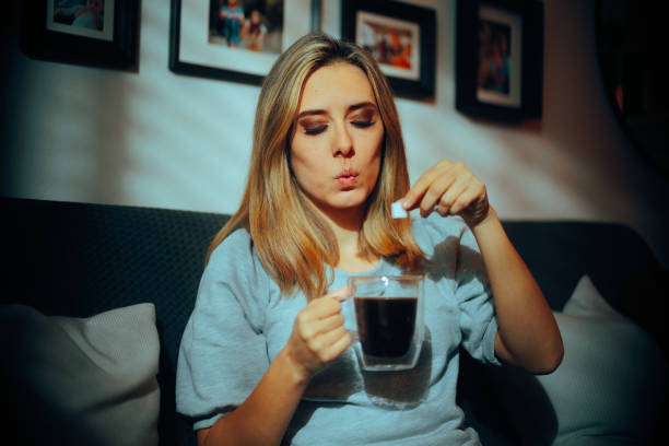 istock Woman Putting one Cube of Sugar in her Black Coffee 2105771535