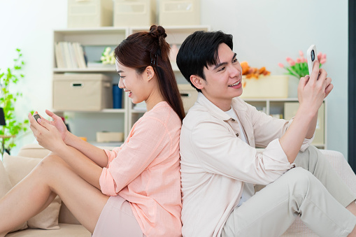 Photo of young Asian couple at home