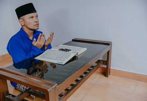 Religious Indonesian muslim man praying inside the mosque.