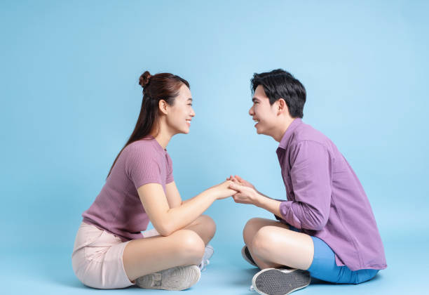 istock Young Asian couple on blue background 2105829345