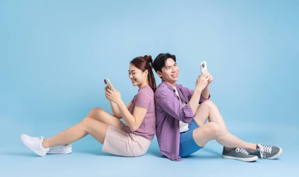 istock Young Asian couple on blue background 2105829349