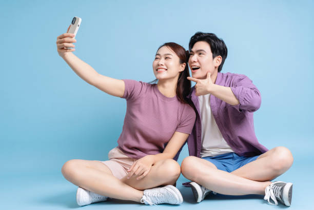 istock Young Asian couple on blue background 2105829361