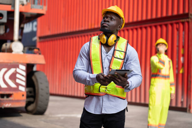 istock Portrait African logistic engineer man worker or foreman working with Asia foreman and forklift container at container site 2105970140