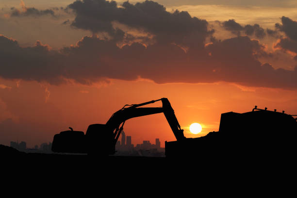 istock Crawler excavators silhouette are digging the soil in the construction site. 2105992522